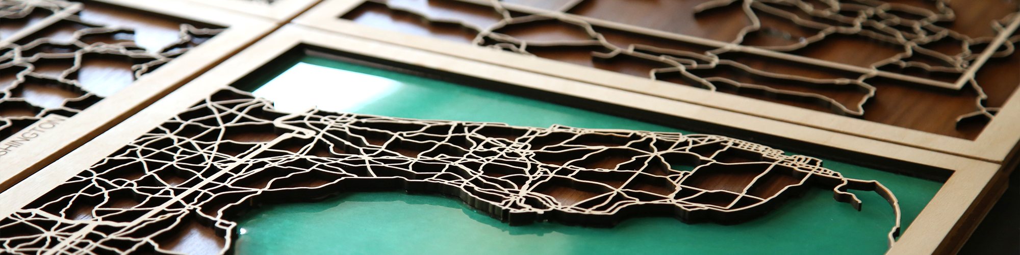 Laser-cut wooden maps of Florida and Washington with turquoise water inlays