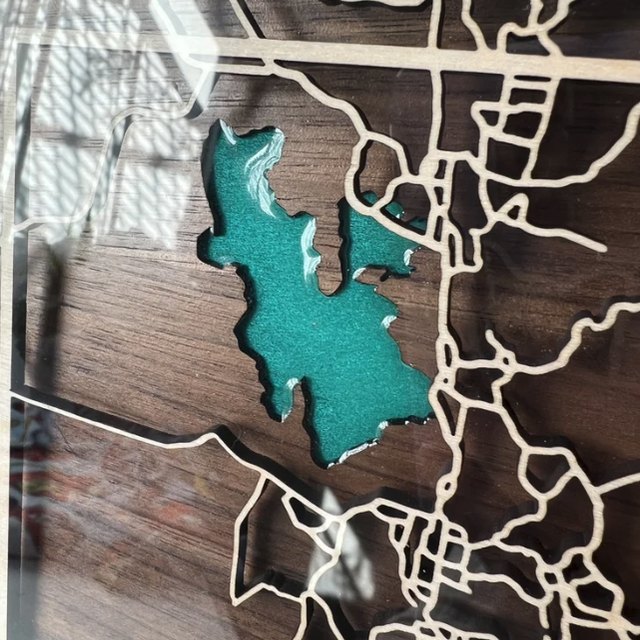 Close-up of a wooden map with a turquoise lake